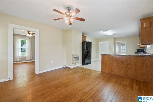 114NW Morgan Ave, Cullman, AL 35055 - unfurnished living room featuring heating unit, light wood finished floors, ceiling fan, baseboards, and a sink