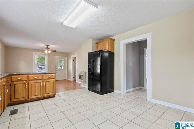 114NW Morgan Ave, Cullman, AL 35055 - kitchen with black fridge with ice dispenser, ceiling fan, a textured ceiling, baseboards, and brown cabinetry
