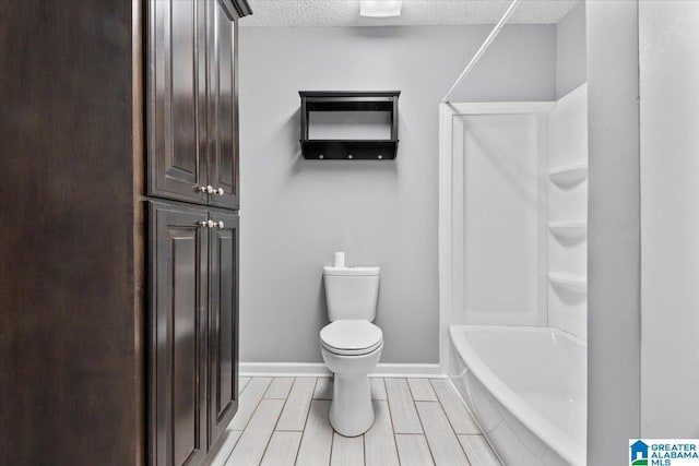 114NW Morgan Ave, Cullman, AL 35055 - bathroom featuring toilet, a textured ceiling, baseboards, bathtub / shower combination, and wood finish floors