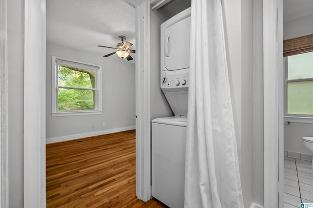 4763 7th Ct S, Birmingham, AL 35222 - laundry room featuring stacked washer / dryer, ceiling fan, wood finished floors, and baseboards