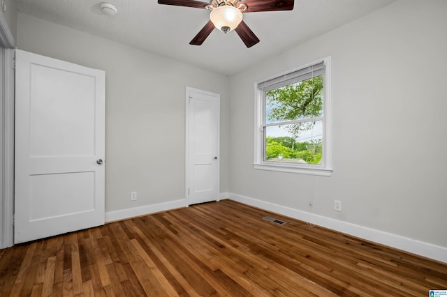 4763 7th Ct S, Birmingham, AL 35222 - unfurnished bedroom featuring baseboards, hardwood / wood-style floors, and a ceiling fan