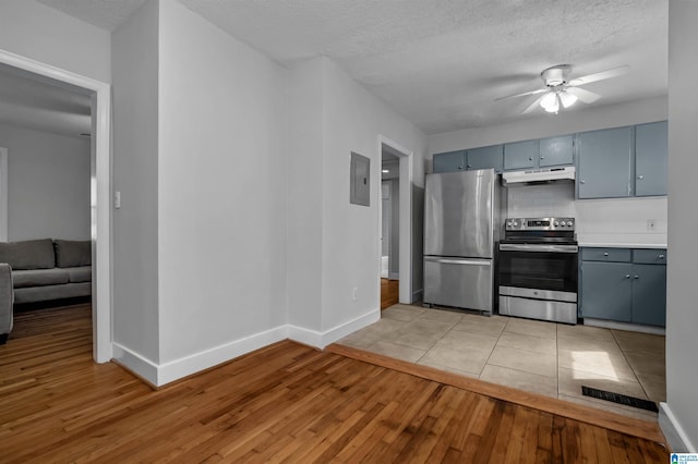 4763 7th Ct S, Birmingham, AL 35222 - kitchen featuring stainless steel appliances, under cabinet range hood, light wood finished floors, ceiling fan, and baseboards