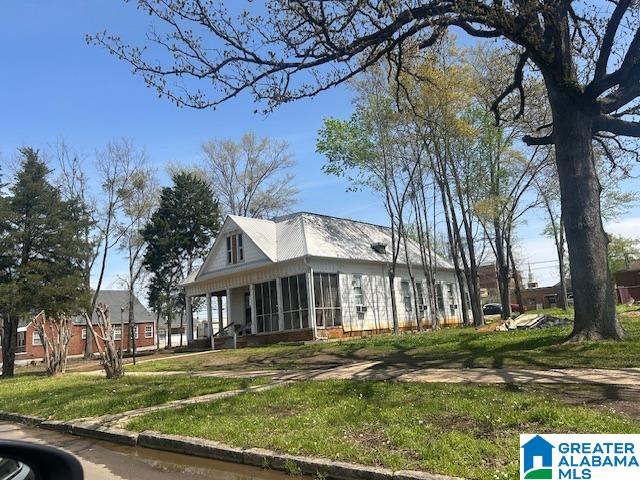 1711 5th Ave N, Bessemer, AL 35020 - view of side of property featuring a sunroom and a lawn