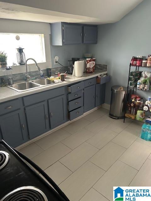 1711 5th Ave N, Bessemer, AL 35020 - kitchen featuring gray cabinetry, a sink, light countertops, and black / electric stove