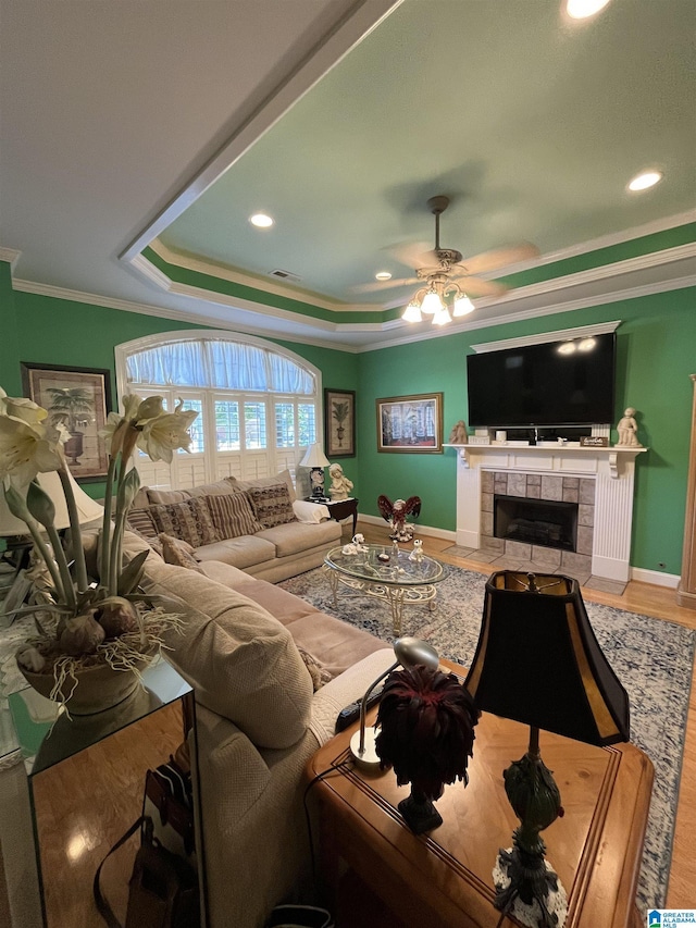 50 Ashton Ln, Sylacauga, AL 35150 - living area with crown molding, a ceiling fan, a tiled fireplace, wood finished floors, and baseboards