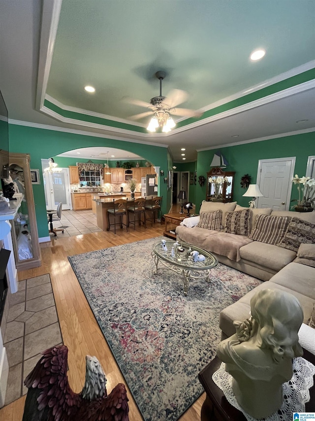 50 Ashton Ln, Sylacauga, AL 35150 - living room with arched walkways, a tray ceiling, ceiling fan, light wood-type flooring, and ornamental molding