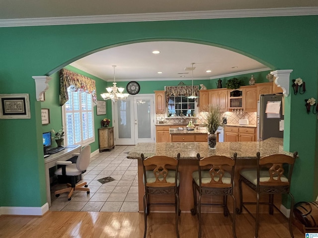 50 Ashton Ln, Sylacauga, AL 35150 - kitchen with freestanding refrigerator, arched walkways, an office area, a breakfast bar area, and crown molding
