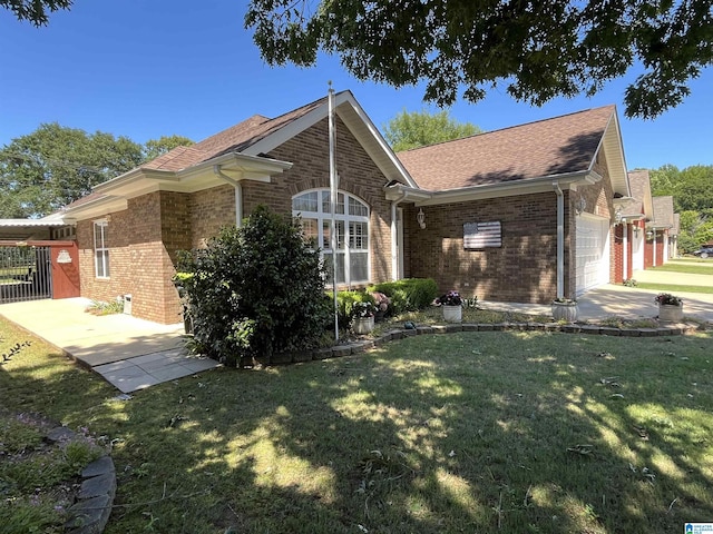 50 Ashton Ln, Sylacauga, AL 35150 - view of property exterior featuring an attached garage, brick siding, a yard, and roof with shingles