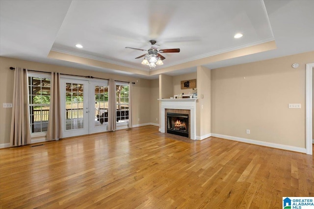 255 Savannah Ln, Cleveland, AL 35049 - unfurnished living room with a tray ceiling, a ceiling fan, ornamental molding, light wood-type flooring, and baseboards