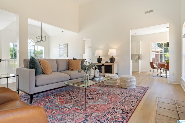773 Old Cahaba Dr, Helena, AL 35080 - living room featuring healthy amount of natural light, light wood-style flooring, a towering ceiling, a chandelier, and baseboards