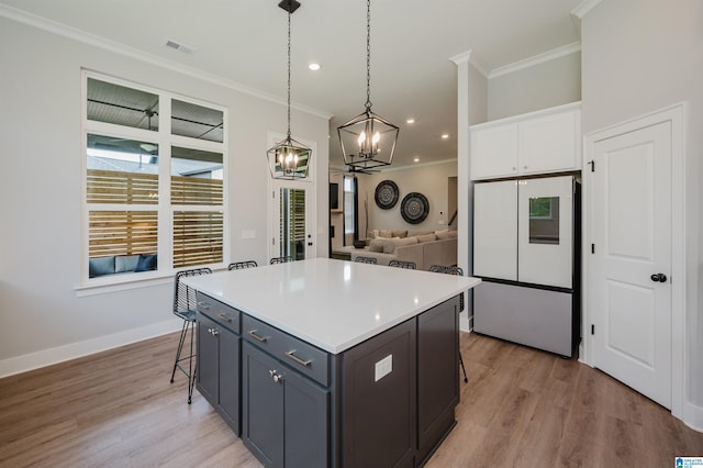 4651 Silas Ave, Hoover, AL 35244 - kitchen with freestanding refrigerator, a chandelier, a kitchen breakfast bar, crown molding, and white cabinets