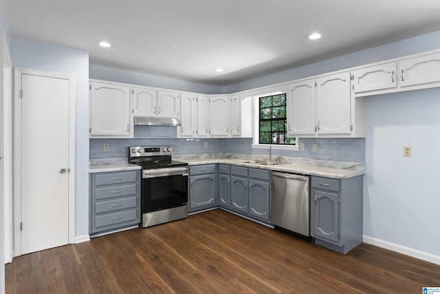 1718 Teakwood Ln, Birmingham, AL 35235 - kitchen featuring appliances with stainless steel finishes, gray cabinetry, under cabinet range hood, dark wood-style flooring, and recessed lighting