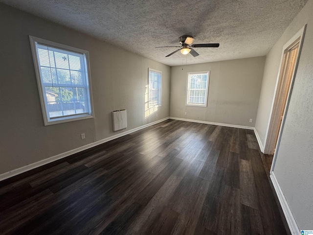 804 Elm Ave, Gadsden, AL 35903 - unfurnished room with dark wood-style floors, a textured ceiling, baseboards, a ceiling fan, and heating unit