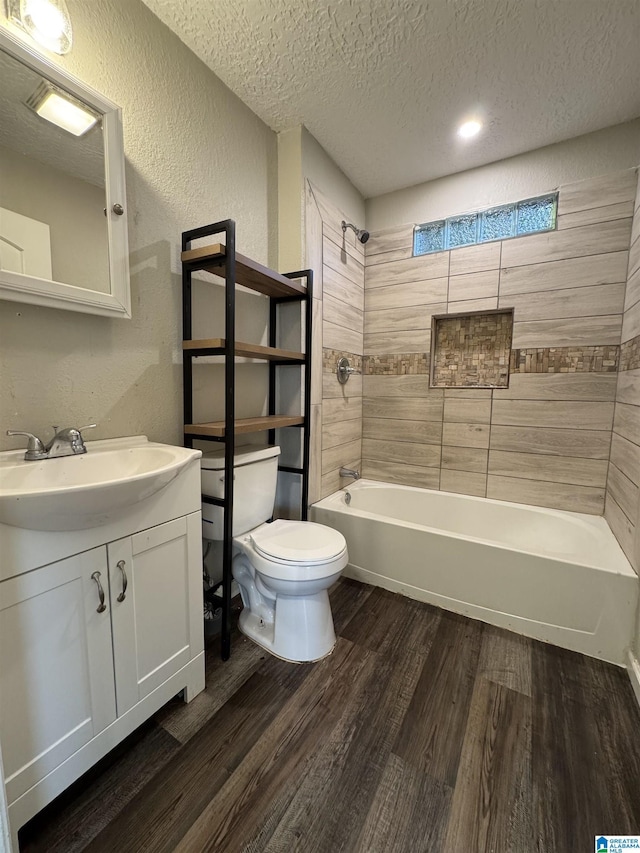 804 Elm Ave, Gadsden, AL 35903 - bathroom with toilet, wood finished floors, a textured ceiling, a textured wall, and shower / tub combination