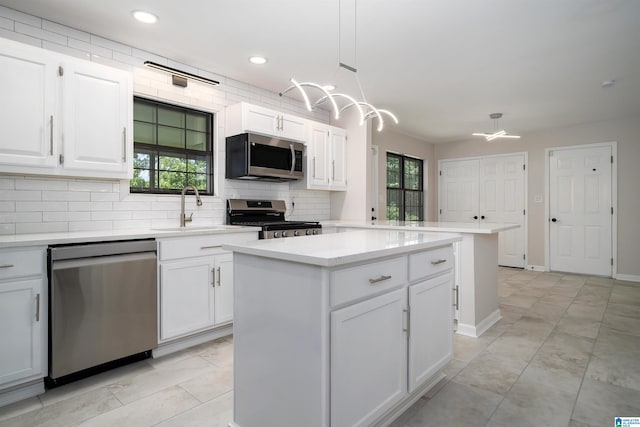 4100 S Shades Crest Rd, Hoover, AL 35244 - kitchen featuring stainless steel appliances, a sink, backsplash, white cabinetry, and a kitchen island