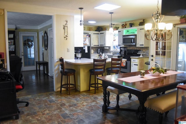3908 Cloverdale Rd, Anniston, AL 36207 - dining area with a chandelier, dark stone finish flooring, and crown molding