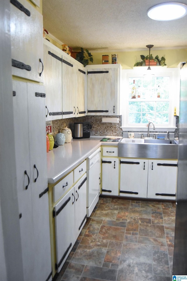3908 Cloverdale Rd, Anniston, AL 36207 - kitchen featuring white dishwasher, tasteful backsplash, a sink, a textured ceiling, and white cabinetry