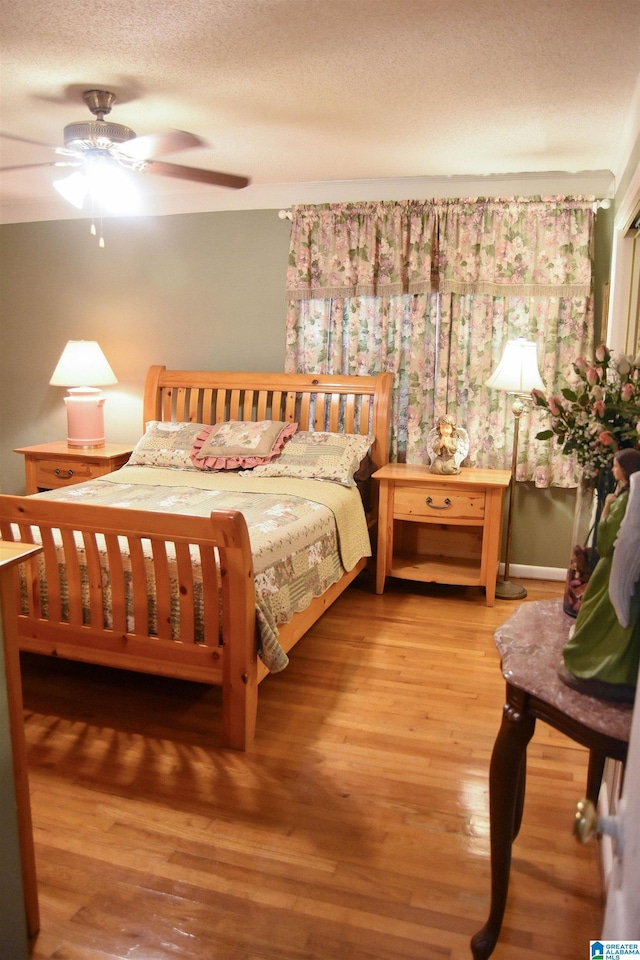 3908 Cloverdale Rd, Anniston, AL 36207 - bedroom with wood finished floors, a ceiling fan, and a textured ceiling