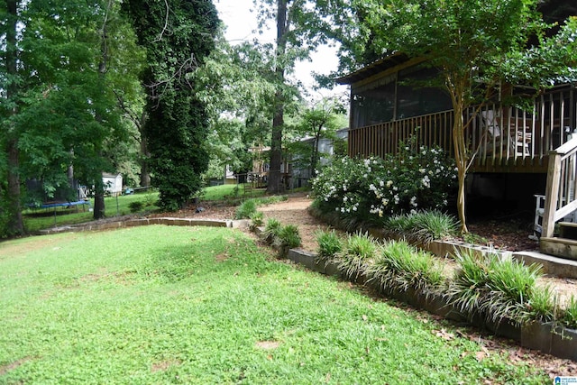 3908 Cloverdale Rd, Anniston, AL 36207 - view of yard featuring a trampoline, a wooden deck, and a sunroom