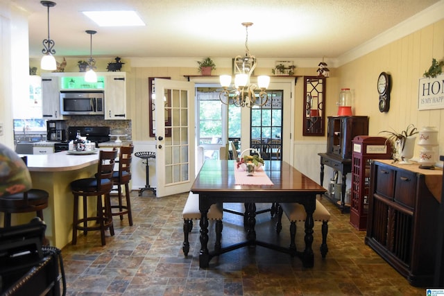 3908 Cloverdale Rd, Anniston, AL 36207 - dining room with a chandelier, crown molding, dark stone finish flooring, and wood walls