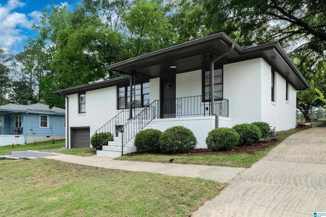 1644 1st St NE, Center Point, AL 35215 - view of front of home featuring a garage, brick siding, a front lawn, covered porch, and stairs