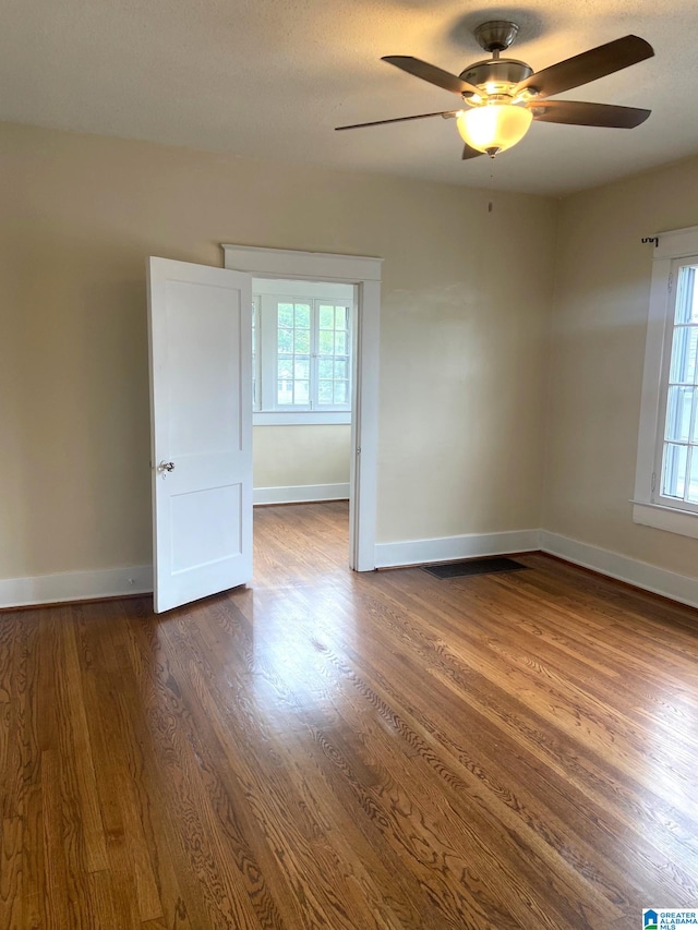 1428 11th Pl S, Birmingham, AL 35205 - unfurnished room featuring plenty of natural light, a ceiling fan, and dark wood-style flooring