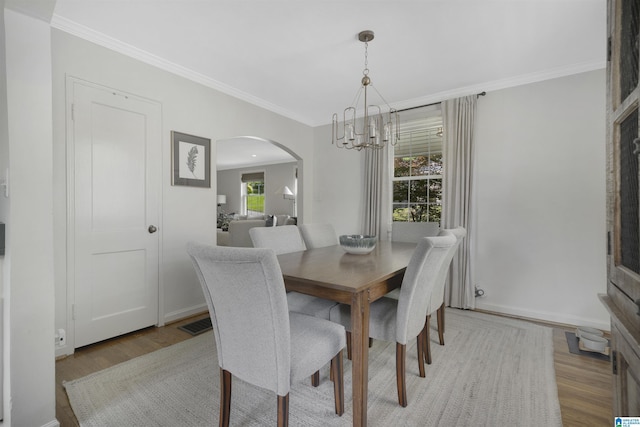 39 Edgehill Rd, Homewood, AL 35209 - dining room with arched walkways, a chandelier, light wood-style flooring, crown molding, and baseboards