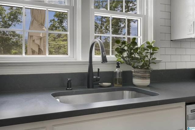 39 Edgehill Rd, Homewood, AL 35209 - kitchen view of a sink, dark countertops, tasteful backsplash, and white cabinetry