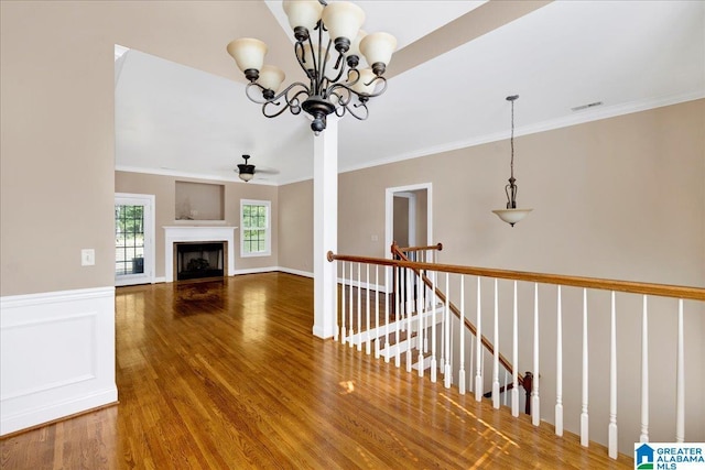 555 Ridgefield Way, Odenville, AL 35120 - unfurnished living room with wood finished floors, ornamental molding, ceiling fan, a chandelier, and a fireplace
