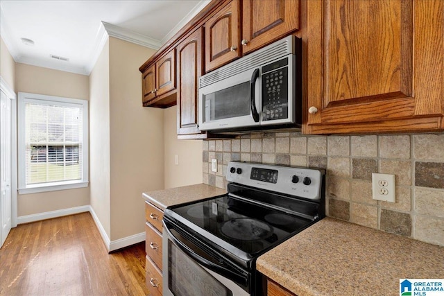555 Ridgefield Way, Odenville, AL 35120 - kitchen with stainless steel appliances, crown molding, baseboards, wood finished floors, and decorative backsplash
