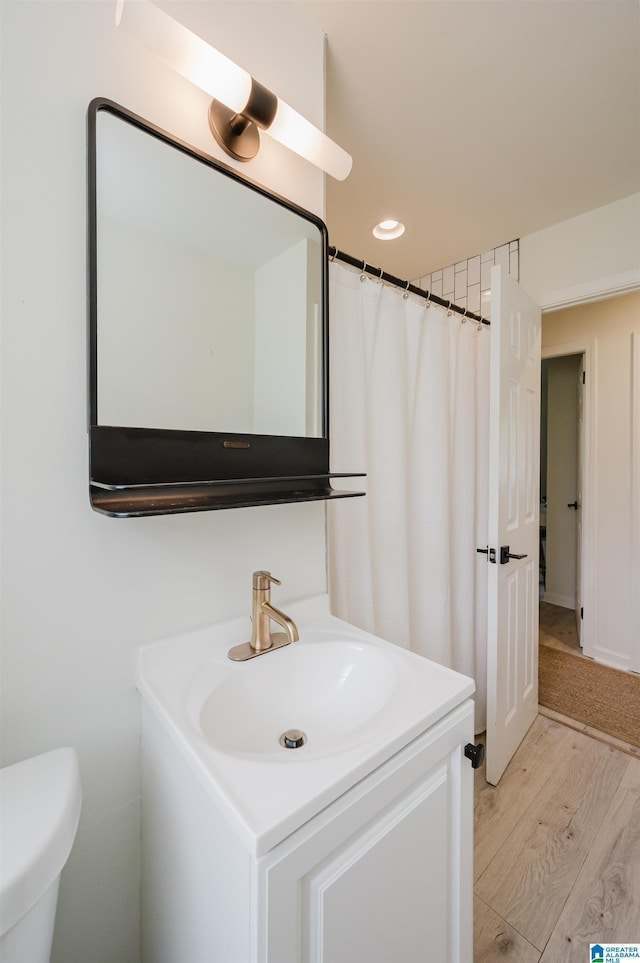 1320 Monticello St, Irondale, AL 35210 - bathroom featuring wood finished floors, vanity, and toilet