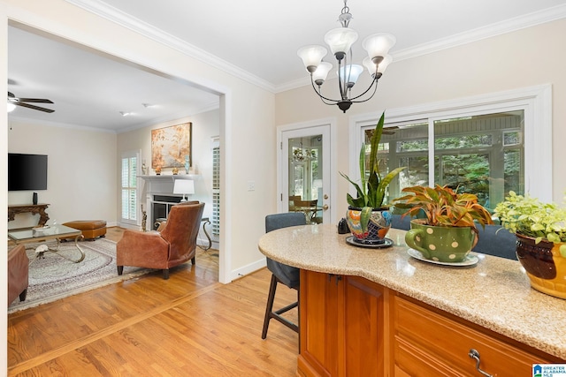 919 Sycamore Dr, Hoover, AL 35244 - kitchen with light wood-style floors, a chandelier, light stone countertops, brown cabinetry, and ornamental molding