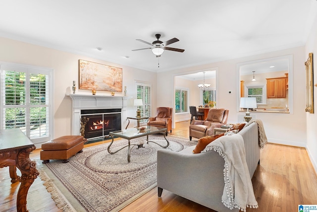 919 Sycamore Dr, Hoover, AL 35244 - living room featuring light wood finished floors, ceiling fan, a warm lit fireplace, baseboards, and crown molding