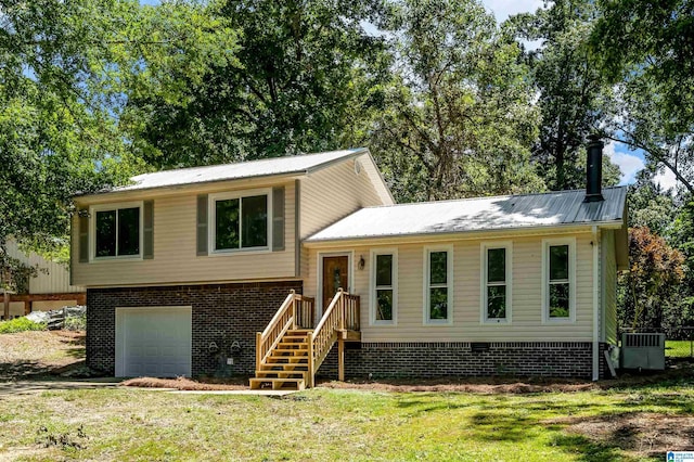 941 Honeysuckle Ln, Moody, AL 35094 - tri-level home featuring metal roof, an attached garage, a front lawn, central AC, and brick siding