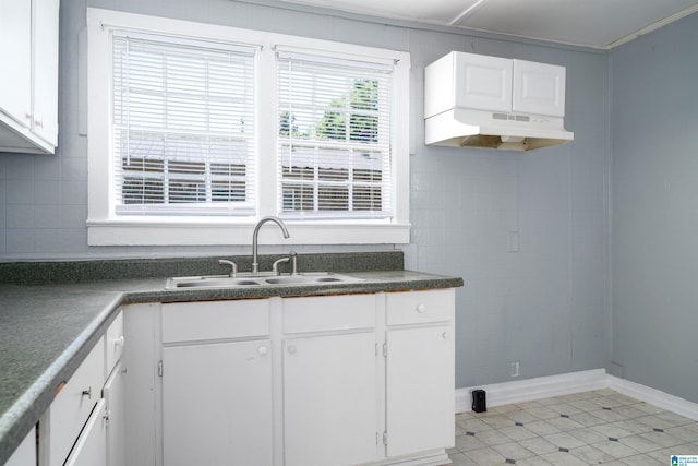 1228 19th Pl SW, Birmingham, AL 35211 - kitchen with a sink, dark countertops, white cabinets, light tile patterned floors, and under cabinet range hood