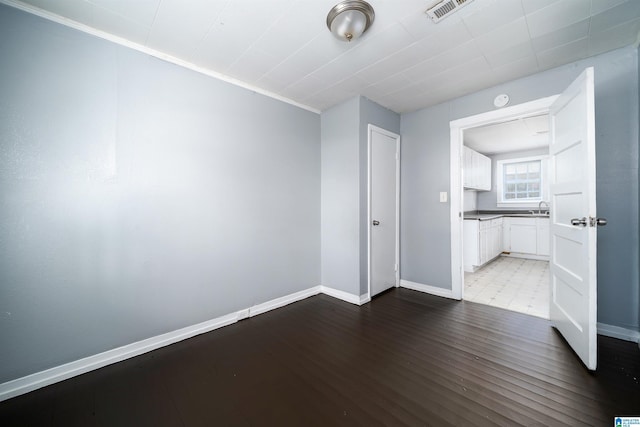 1228 19th Pl SW, Birmingham, AL 35211 - empty room featuring baseboards, wood finished floors, a sink, and crown molding