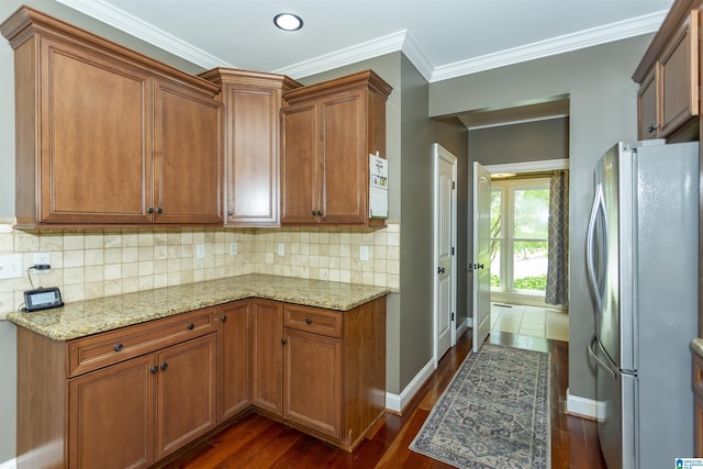 1020 Dunsmore Dr, Chelsea, AL 35043 - kitchen featuring freestanding refrigerator, brown cabinetry, light stone countertops, dark wood finished floors, and ornamental molding