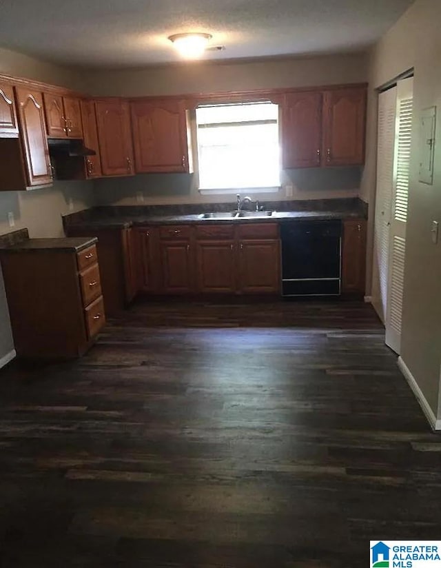 421 Valley Crest Dr, Birmingham, AL 35215 - kitchen featuring dishwasher, dark wood-type flooring, a sink, under cabinet range hood, and dark countertops