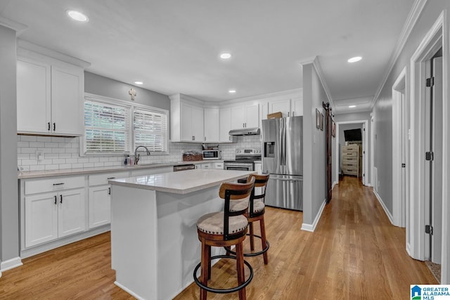 1115 Park Ave, Oneonta, AL 35121 - kitchen with stainless steel appliances, under cabinet range hood, light countertops, white cabinetry, and recessed lighting