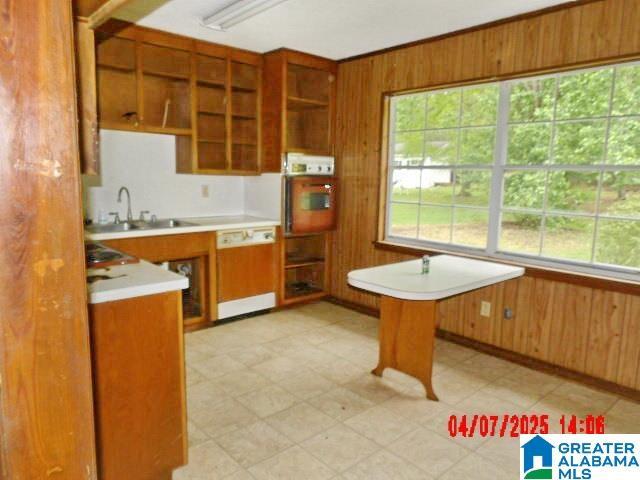 8421 Azalea Dr, Pinson, AL 35126 - kitchen featuring dishwashing machine, a sink, open shelves, plenty of natural light, and wood walls