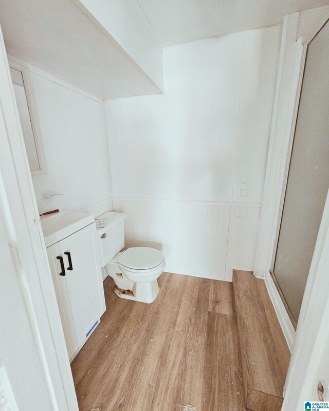 1332 4th Way NW, Center Point, AL 35215 - full bathroom featuring wood finished floors, toilet, vanity, a stall shower, and wainscoting