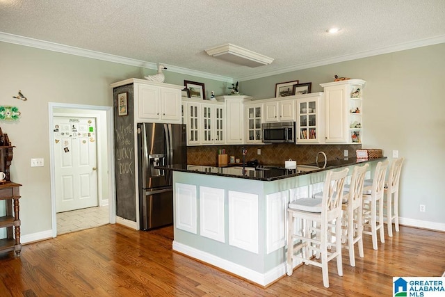 967 Wright Way Dr, Wedowee, AL 36278 - kitchen featuring appliances with stainless steel finishes, a peninsula, white cabinetry, a textured ceiling, and wood finished floors