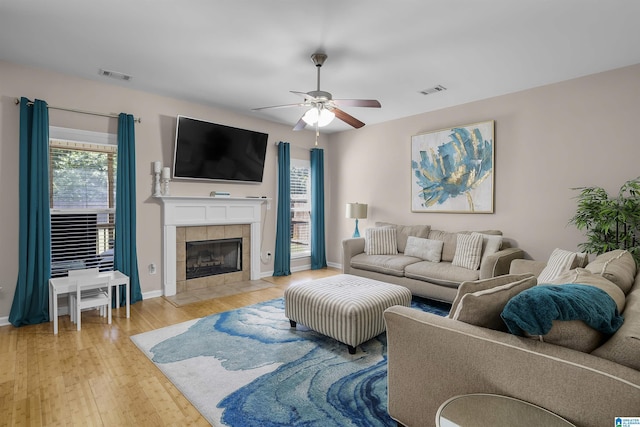 6303 Letson Farms Dr, Bessemer, AL 35022 - living room with light wood-style floors, baseboards, a ceiling fan, and a tiled fireplace