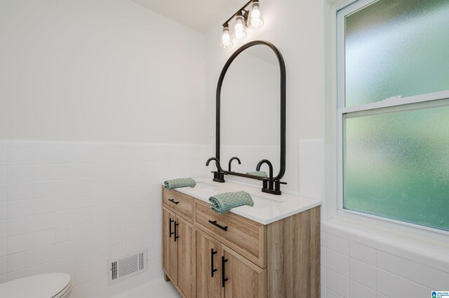 732 Highland Ave, Birmingham, AL 35206 - bathroom with toilet, double vanity, a wainscoted wall, and tile walls