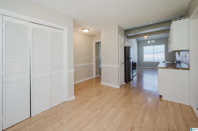1012 Hickory St, Moody, AL 35004 - kitchen featuring freestanding refrigerator, a sink, dark countertops, light wood-style floors, and baseboards