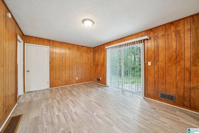 1716 Nancy Ln, Center Point, AL 35215 - unfurnished room with light wood-style flooring, wood walls, and a textured ceiling
