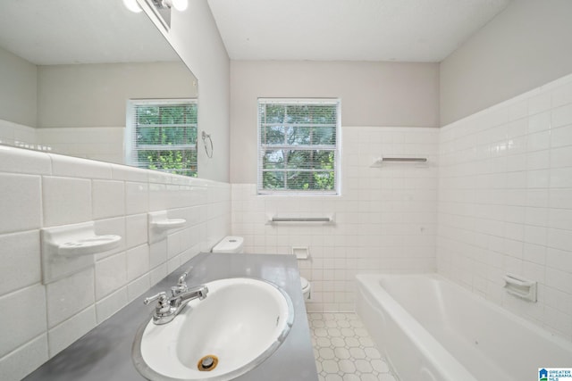 1716 Nancy Ln, Center Point, AL 35215 - bathroom with tile walls, toilet, a bath, a wainscoted wall, and vanity