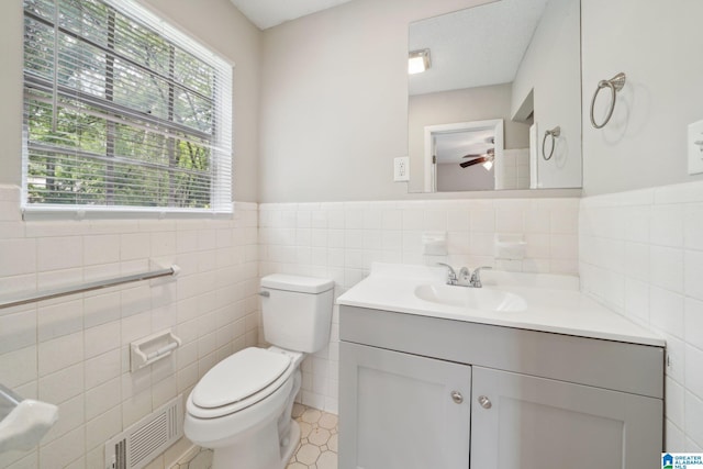 1716 Nancy Ln, Center Point, AL 35215 - bathroom featuring tile walls, toilet, a ceiling fan, vanity, and wainscoting