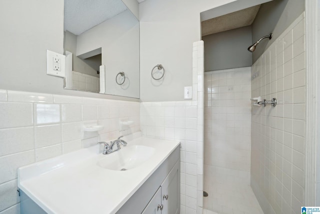 1716 Nancy Ln, Center Point, AL 35215 - bathroom with tiled shower, vanity, tile walls, and a wainscoted wall
