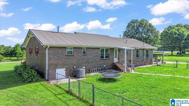 2523 County Road 222, Cullman, AL 35057 - back of property featuring brick siding, metal roof, a trampoline, central AC unit, and a gate